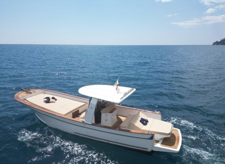 A small motorboat with a white and wooden deck, equipped with a table and seating. 5