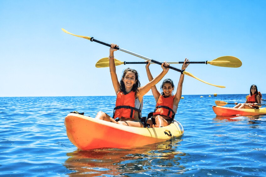 Two people in a yellow kayak on a calm sea, holding paddles. 5