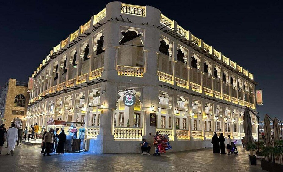 A brightly lit building with ornate balconies and a sign reading "Hotel de Ville." 5