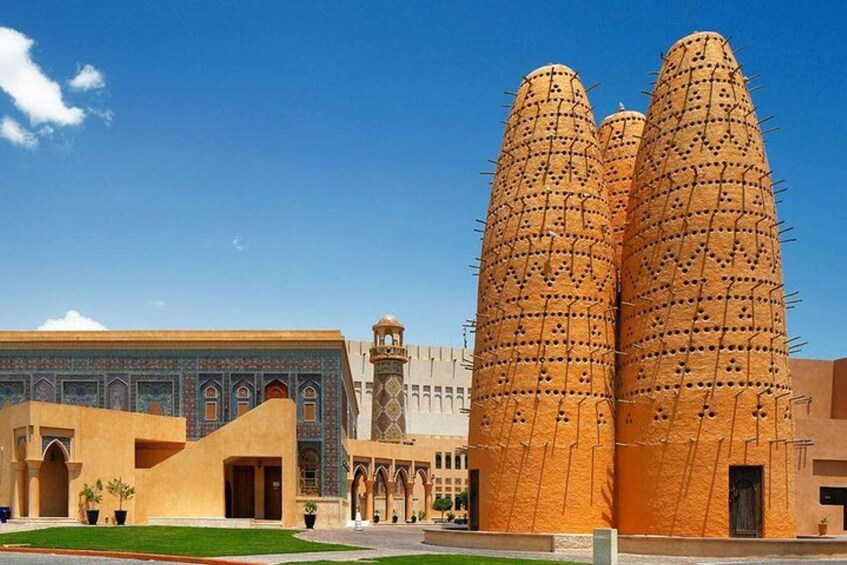 A traditional building with three tall, cylindrical towers covered in a grid of holes. 4