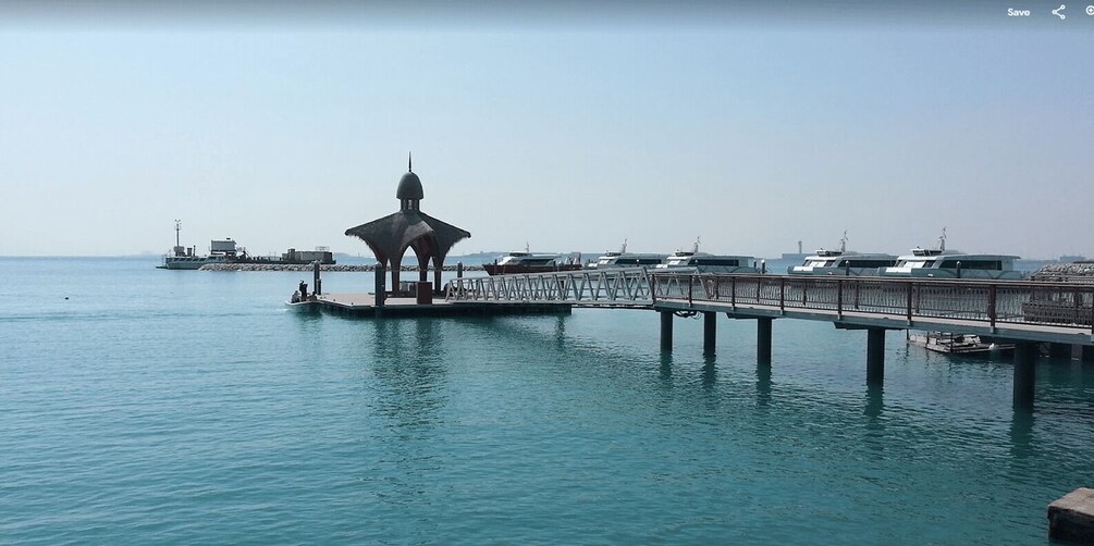 A pier with a gazebo, boats, and a distant ship. 5