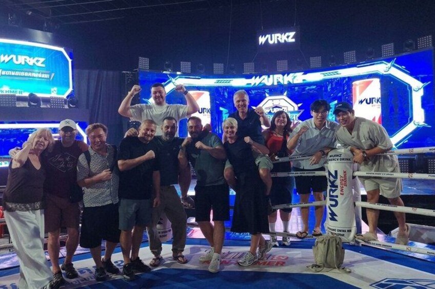 Een groep mensen poseert in een boksring, met een WURKZ logo op de achtergrond. 2
