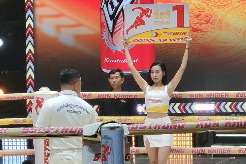 A person holding a sign with '1' and 'BOOSTRONG KUN KHMER' on it. 4