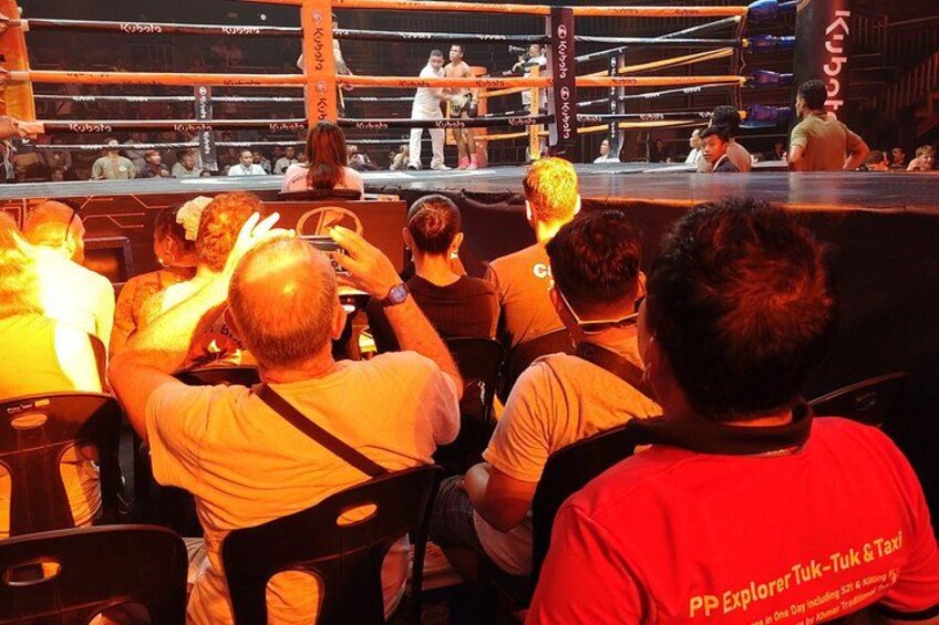 Un ring de boxeo con espectadores sentados al frente. 2