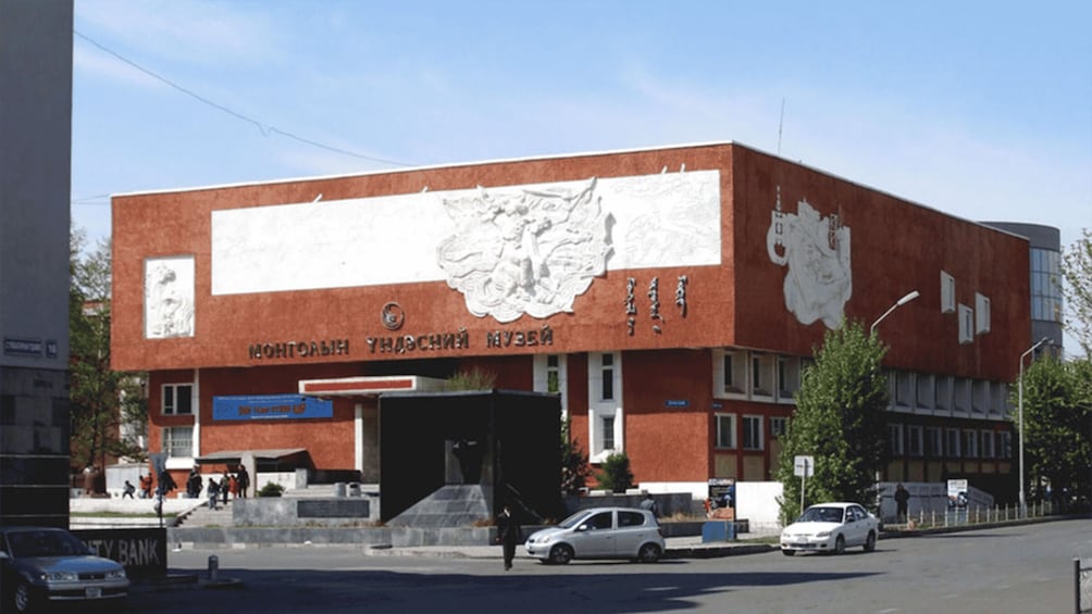 A building with large white murals and text in a foreign language. 4