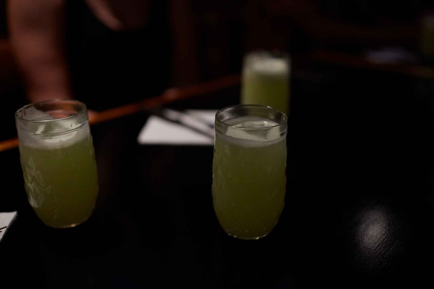 Two glasses of green beverage on a table. 5