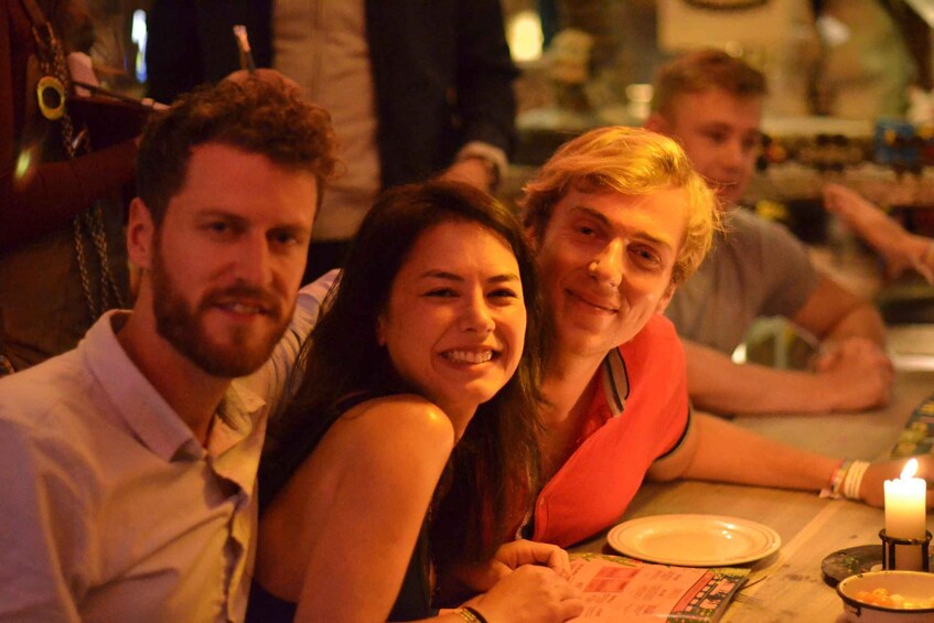 A group of people sitting at a table with a lit candle. 3