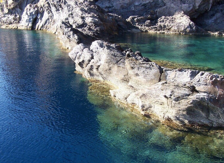 A rocky coastline with clear blue waters. 2