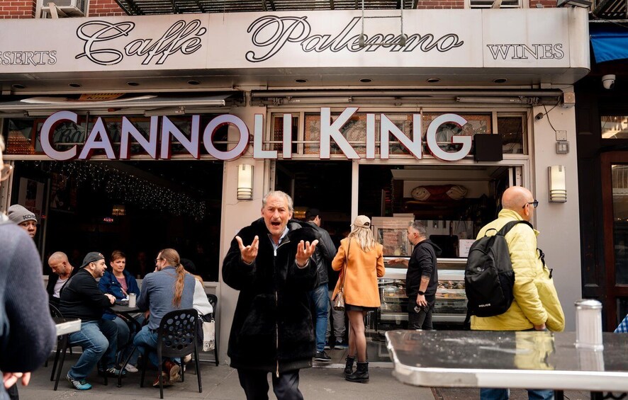 Una escena callejera con un café llamado 'Caffè Palomino' y una tienda de vinos llamada 'CANNOLIKING'. 1