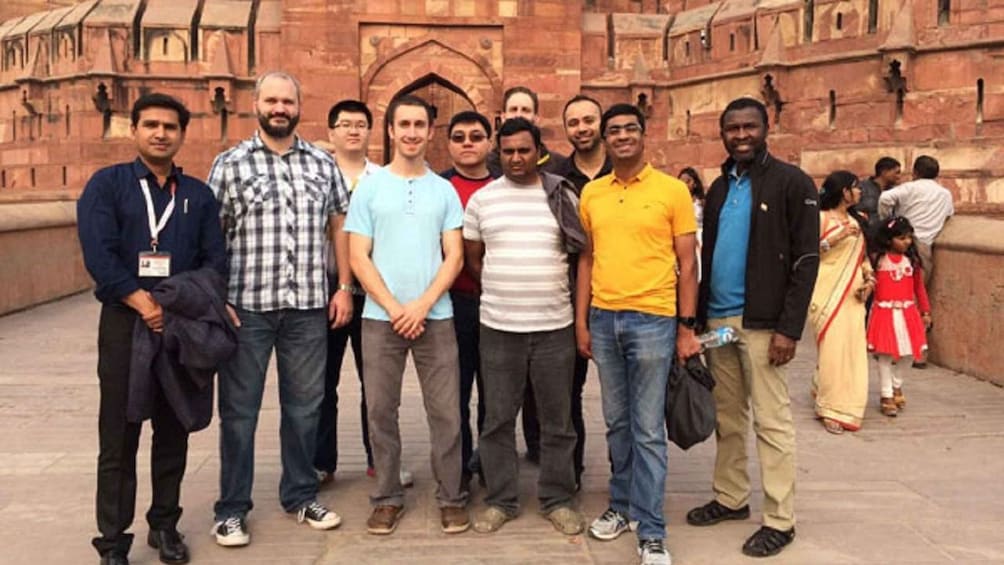 A group of people standing in front of a historic building with intricate architecture. 2