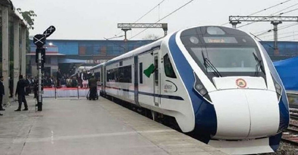 A modern train at a station platform with a clear sky. 1