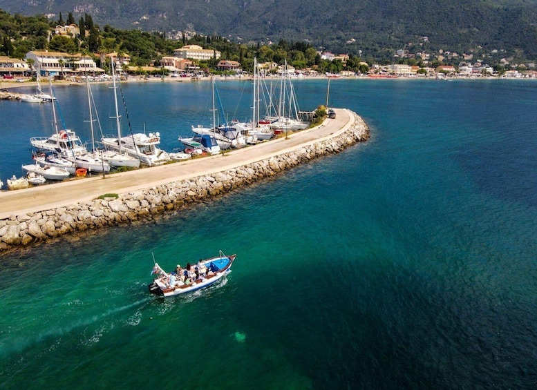 A coastal marina with boats, a rocky breakwater, and a mountainous backdrop. 3