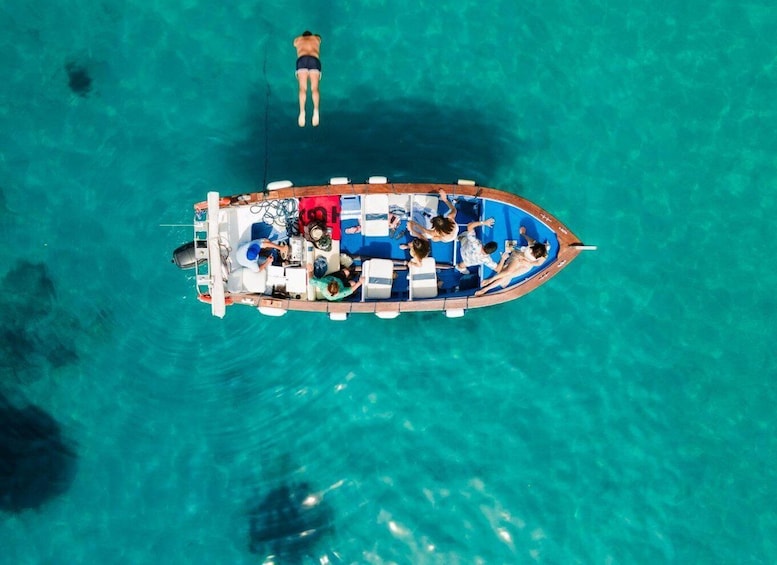 A boat with people on board, surrounded by clear turquoise water. 1