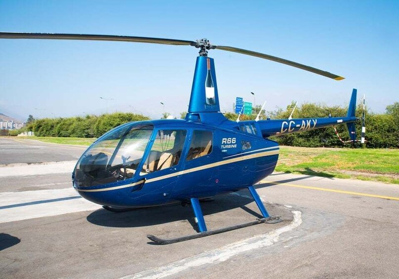 A blue helicopter with registration CC-AXY on a tarmac. 1