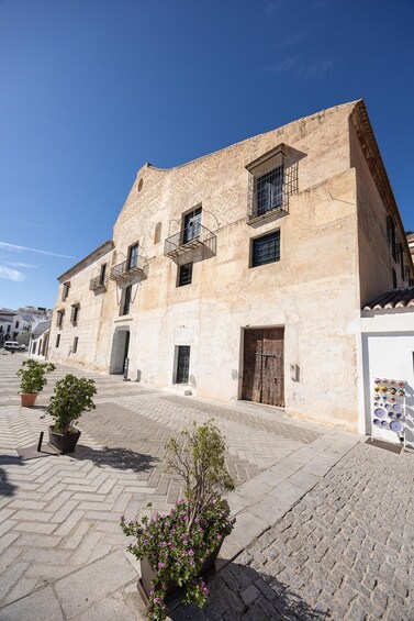 A historic building with a stone facade, multiple windows, and a small balcony. 5