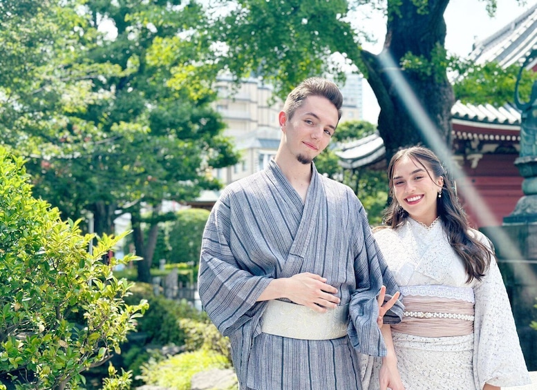 A couple in traditional attire standing in a garden with a building in the background. 4