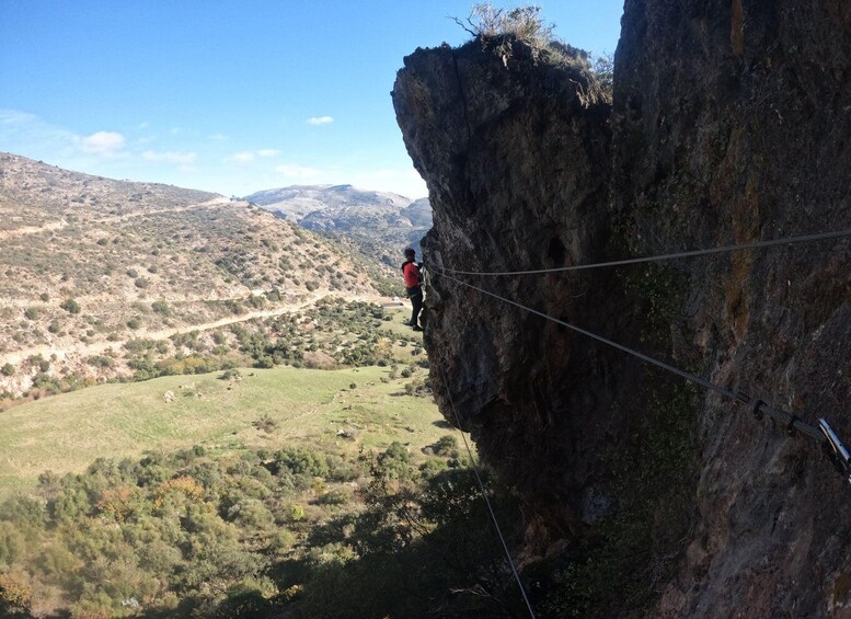 A person rappelling down a cliff with a rope. 5