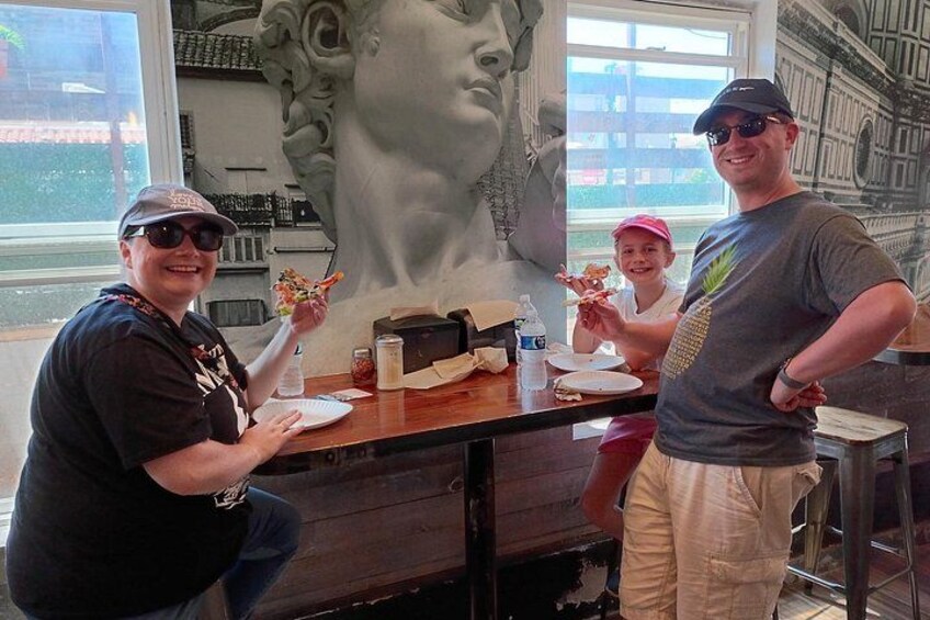 A restaurant interior with a mural, a counter, and people dining. 2