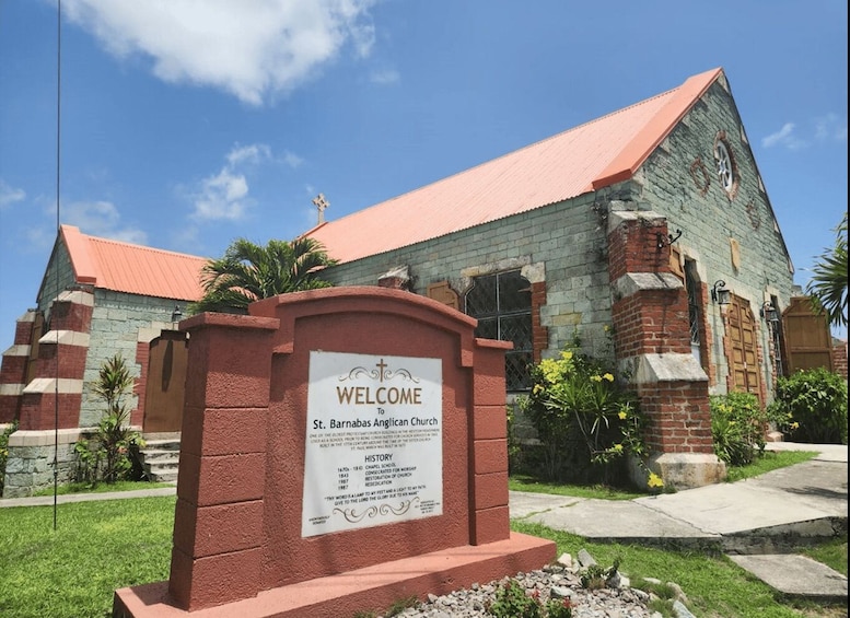 A church with a red roof and a sign welcoming visitors to St. Barnabas Anglican Church. 4