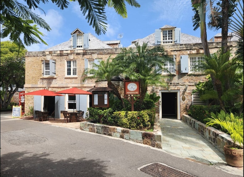 A historic building with a restaurant sign, outdoor seating, and palm trees. 1