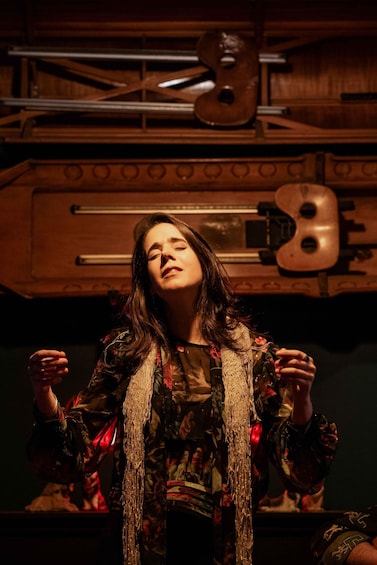 Una persona en una habitación, con un violín y una guitarra al fondo. 3