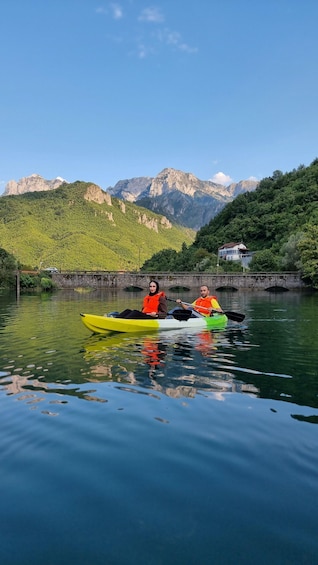 Two kayaks on calm water with a mountain backdrop. 1