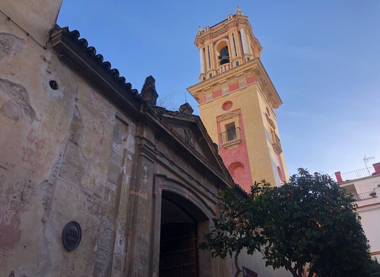 A historic building with a bell tower and a tree in the foreground. 3