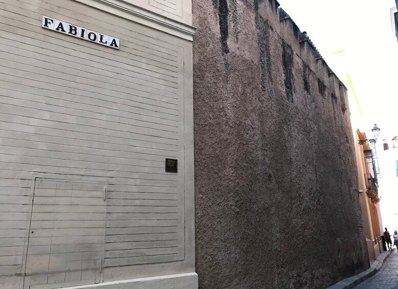A building with a sign reading "FABIOLA" and a textured wall. 4