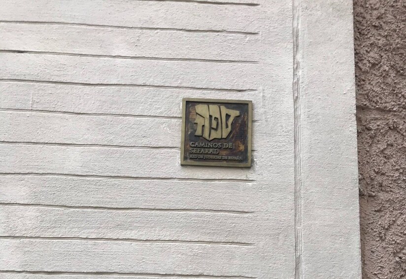 A plaque on a white wall with the text "CAMINOS DE SEFARAD". 1
