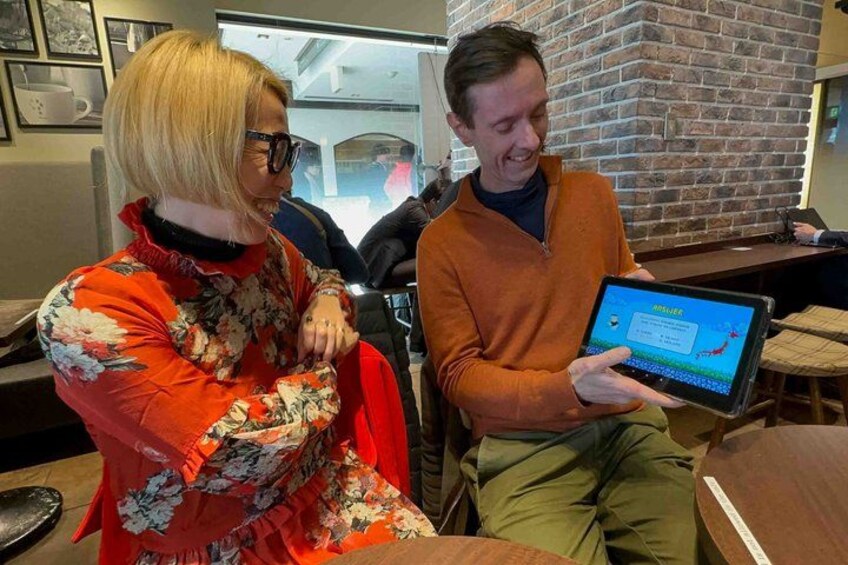Une personne tenant une tablette dans un café aux murs de briques et au mobilier en bois. 2