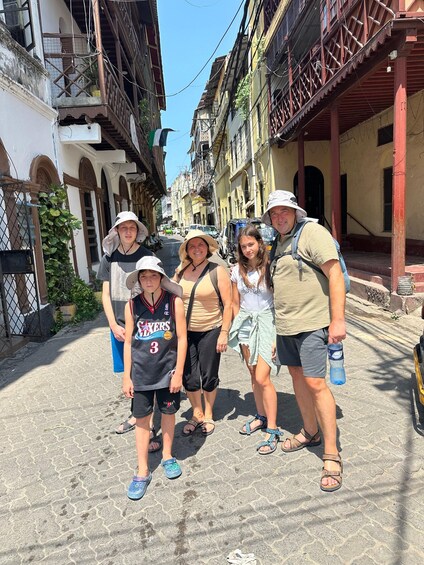 A group of people standing on a cobblestone street in a historic town with buildings featuring balconies and arches. 4