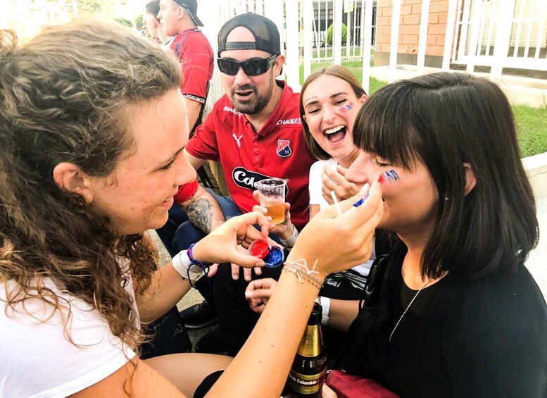 People sitting outdoors, holding drinks and snacks. 5