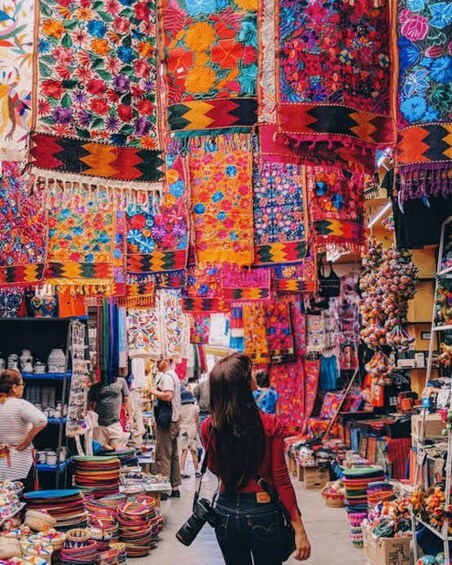 Een levendige markt vol kleurrijke textielproducten en handwerk. 2