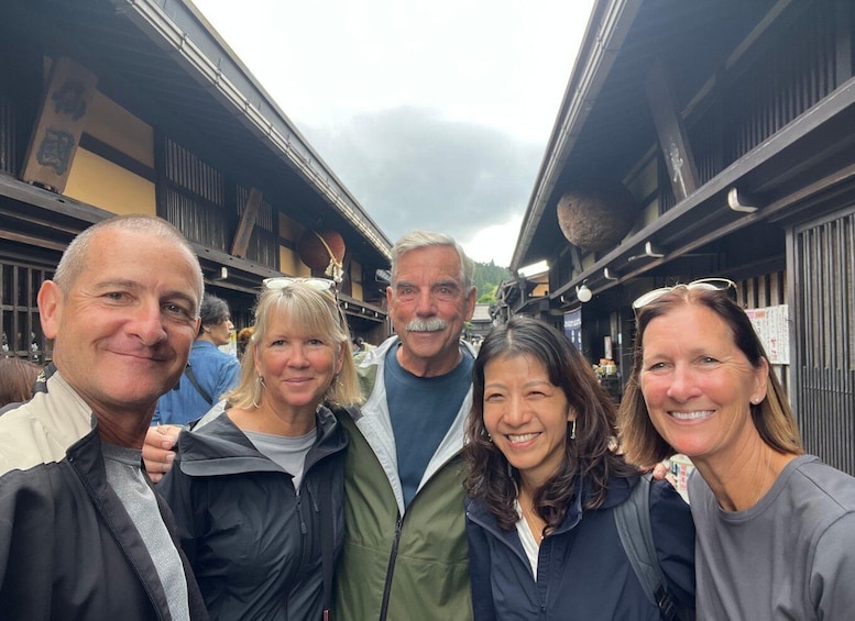 A group of people standing in a covered outdoor market with traditional architecture. 1