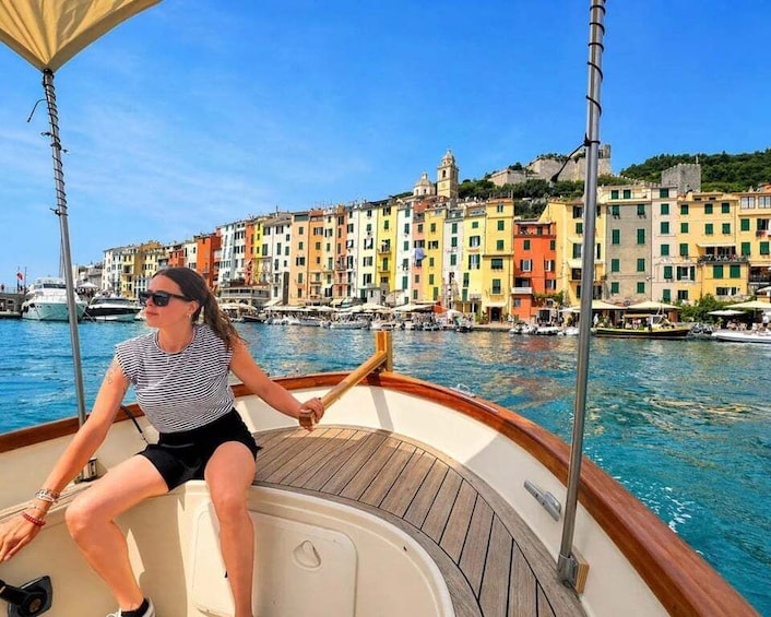 A woman on a boat with a colorful waterfront cityscape in the background. 5