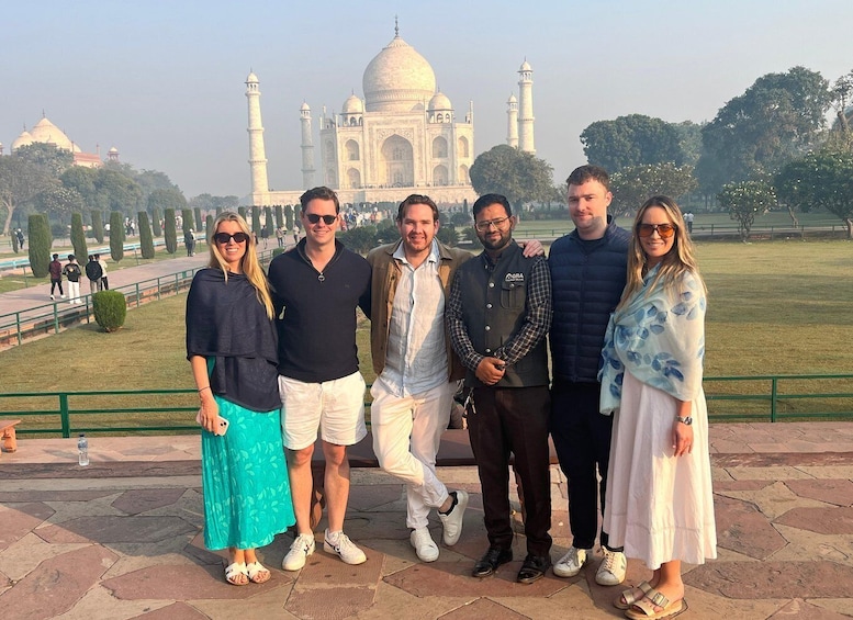 A group of people standing in front of the Taj Mahal. 1