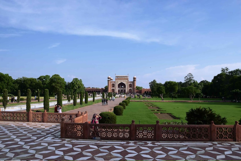 A large, historic building with domed towers, surrounded by well-maintained gardens and pathways. 3