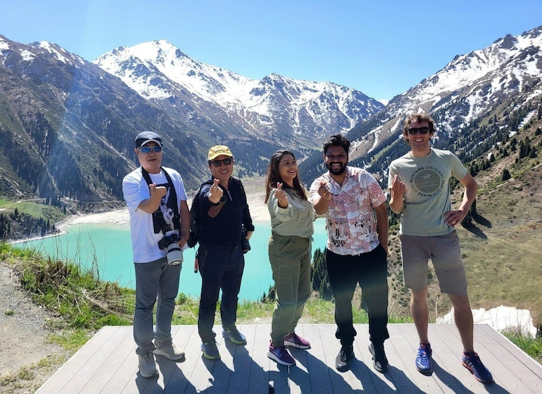 A group of people standing on a wooden platform with a mountainous landscape in the background. 4
