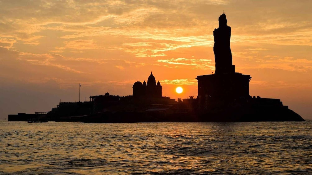 A sunset over a cityscape with prominent buildings and a statue. 2
