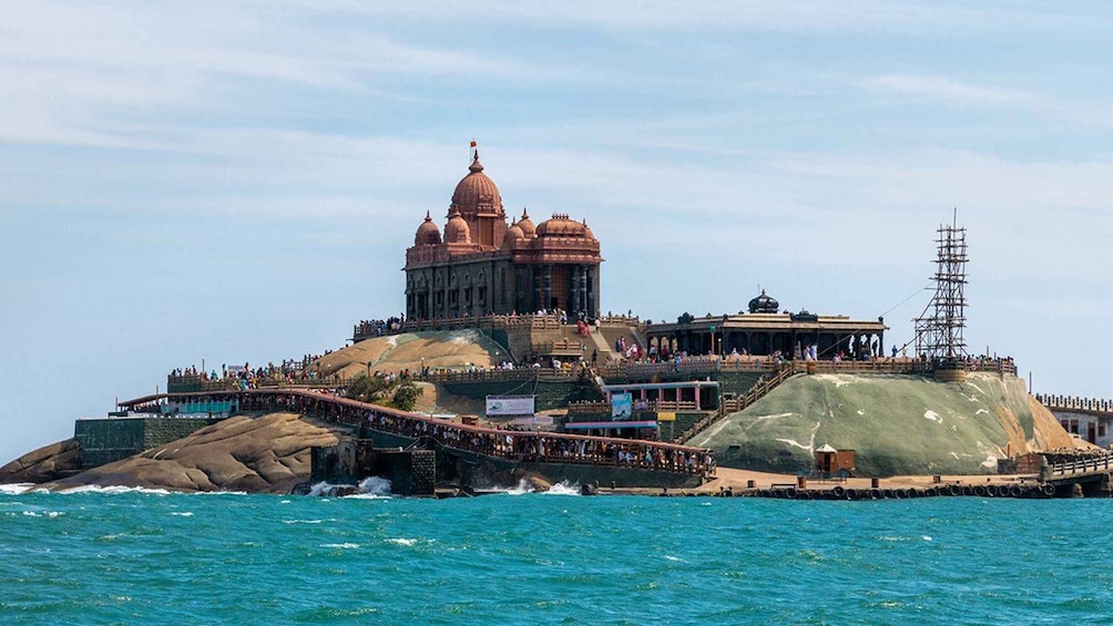 A historic temple complex on an island with a large dome, a bridge, and a lighthouse. 1