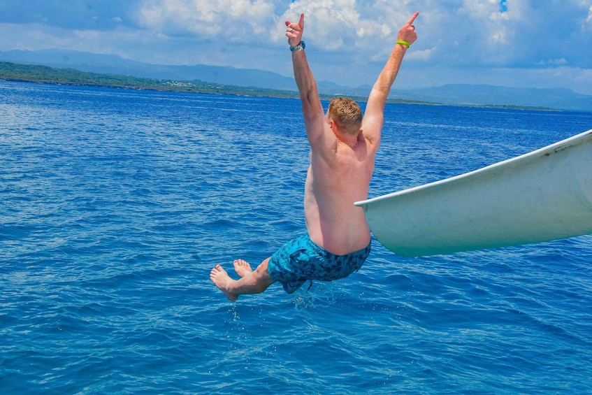 Une personne en plein vol, tenant une planche de surf, plonge dans l’océan. 3