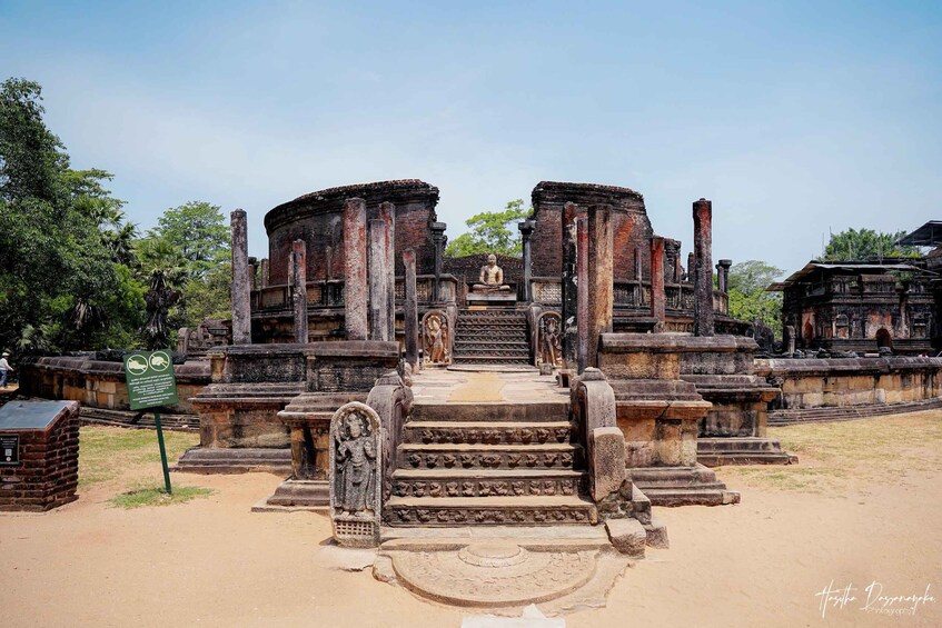 An ancient temple with a central statue, stone steps, and surrounding ruins. 1