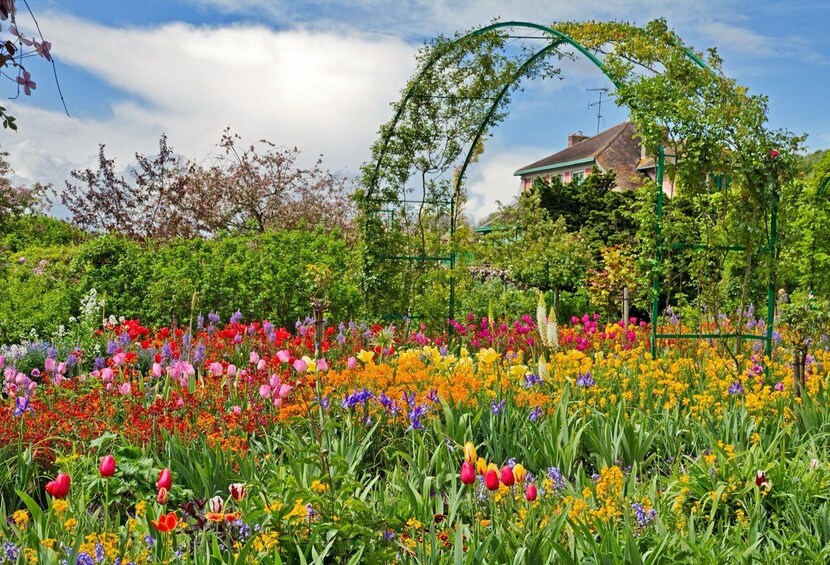 Un jardin luxuriant, parsemé de fleurs aux couleurs vives, et agrémenté d’une arche verdoyante. 5