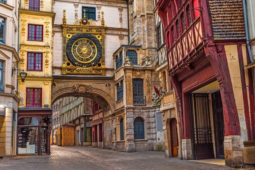 A street with a large ornate clock, historic buildings, and a cobblestone street. 5