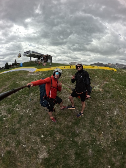 Two people on a grassy hill with a cable car in the background. 4