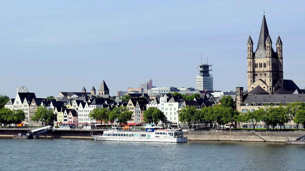 A river with a boat, a bridge, and a cityscape with historic buildings and a church. 2