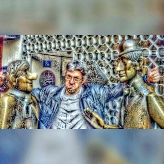 A person in a leather jacket surrounded by metallic sculptures. 1