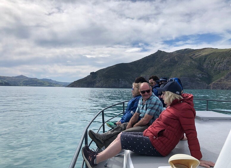 People on a boat with a mountainous landscape in the background. 4