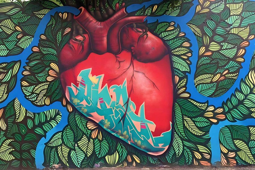 A mural of a heart with graffiti on a wall surrounded by leaf patterns. 1