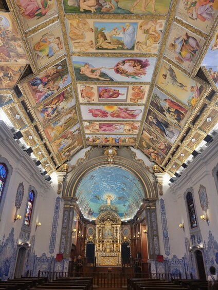A church interior with a detailed ceiling fresco, a central dome with a starry sky, and ornate altars. 3
